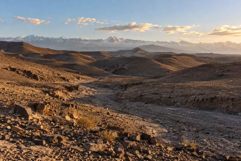The bare rock and dry riverbeds of the Agafay in late afternoon light