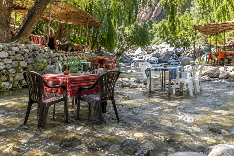 Riverside restaurant tables set in the shallows at Setti Fatma